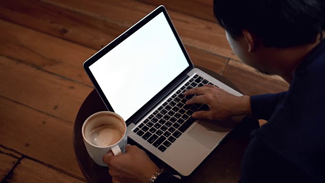4k视频场景的亚洲商人与休闲服装喝咖啡和工作与白屏笔记本电脑在咖啡馆，生活方式和休闲概念视频素材