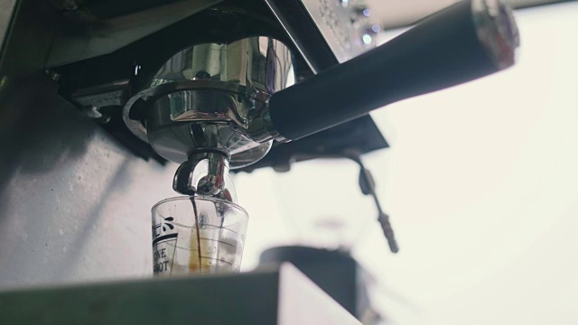 咖啡从机器滴进杯子。视频素材