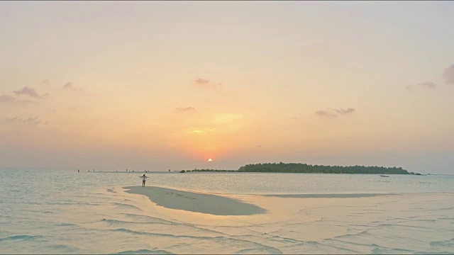 无忧无虑的女人在田园诗般的热带海滩被海洋包围在日落，马尔代夫视频素材