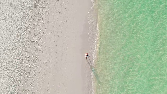 女子走在阳光明媚，田园般的热带海滩，马尔代夫视频素材