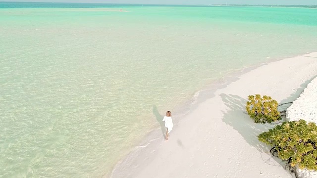 女士走在阳光明媚，田园般的热带海滩，马尔代夫视频素材