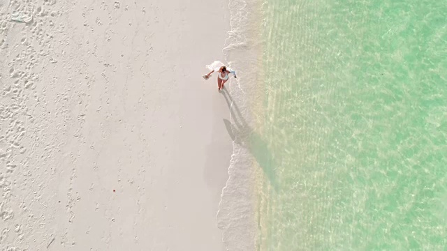 女子走在阳光明媚，田园般的热带海滩，马尔代夫视频下载