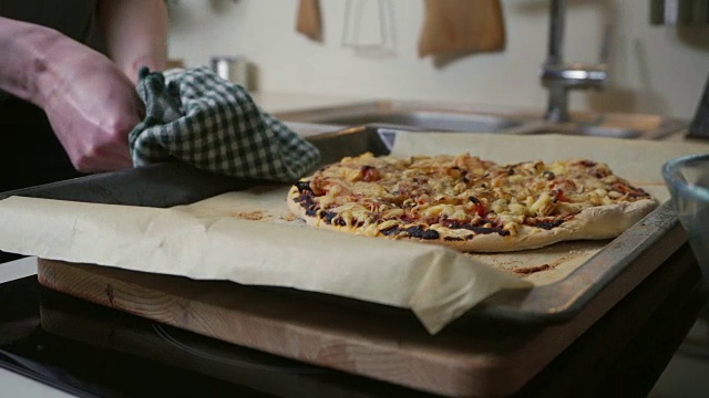 年轻女子把家里做的披萨从烤箱里拿出来视频素材
