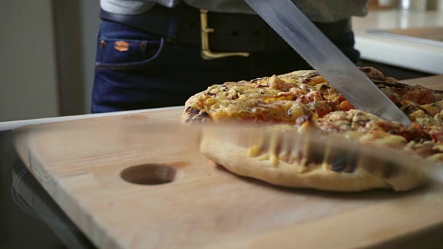 年轻女子正在切家里做的披萨视频素材