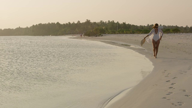 女士走在宁静的热带海滩日落，马尔代夫视频素材
