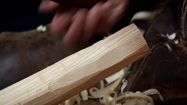 一根木杆用工具粗略地塑造成形状，产生刨花。视频下载
