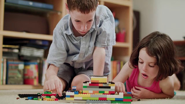 两个孩子在家里玩乐高积木视频素材