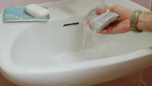 一个男人用刷子清洁浴室水槽的手视频下载