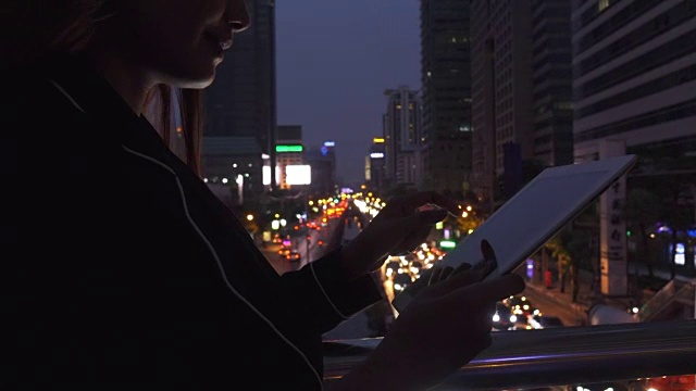 晚上在城市里使用平板电脑的女人视频素材
