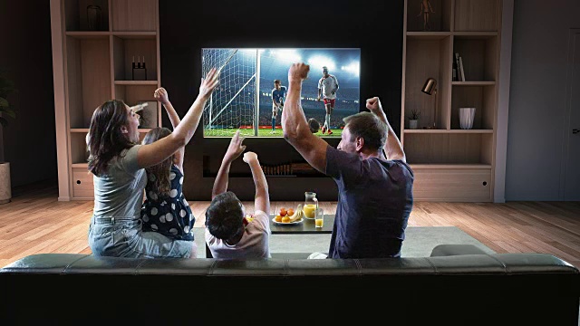 一个家庭正在看电视上的足球时刻，庆祝进球视频素材