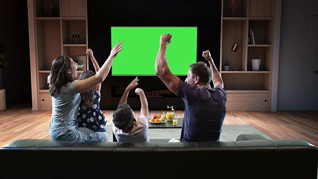 一个家庭正在看电视，庆祝一些快乐的时刻视频购买