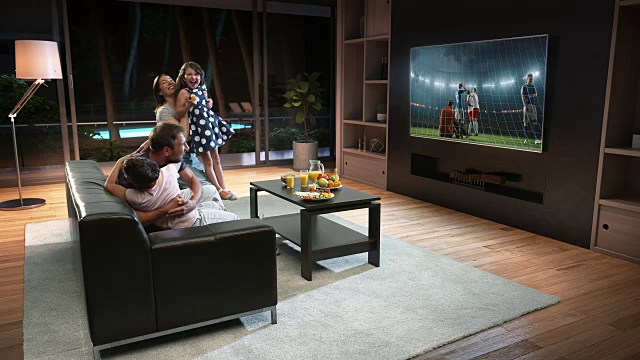 一个家庭正在看电视上的足球时刻，庆祝进球视频素材