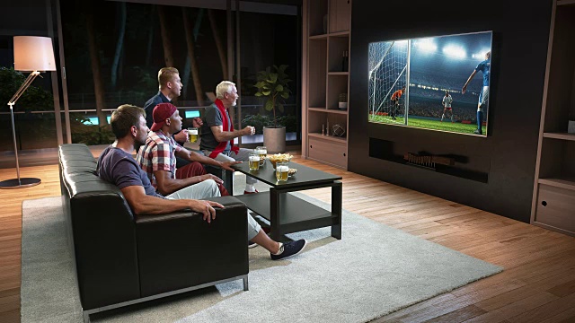 一群球迷正在看电视上的足球时刻，庆祝进球视频素材