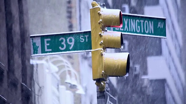 在一场暴风雪中，纽约市的交通灯和列克星敦大街39号的标志被冰雪覆盖视频下载