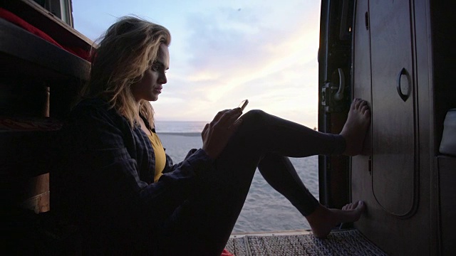 一个年轻的女人在黄昏时分在她的露营车里闲逛视频素材