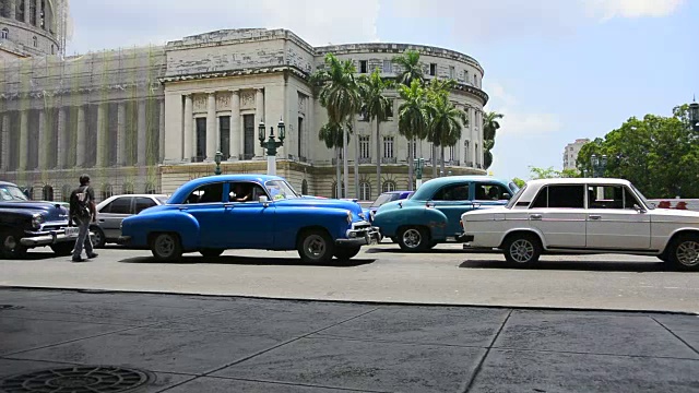 古巴哈瓦那:在El Capitolio建筑前，各种各样的汽车视频下载