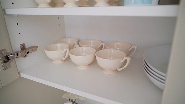 茶杯和茶碟放在橱柜的架子上视频素材