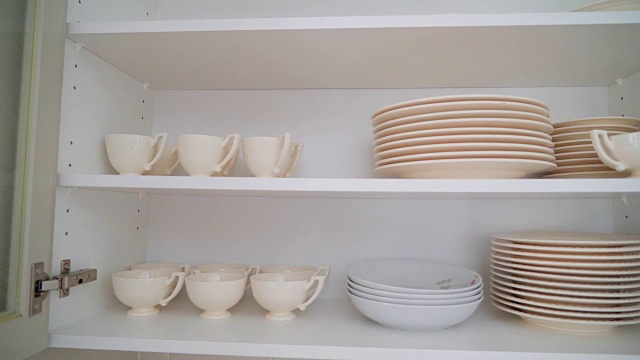 瓷杯和盘子放在橱柜架上视频素材