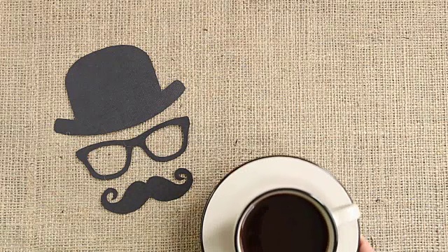 男性剪影图案与胡子，眼镜和帽子与咖啡杯在粗麻布的背景。十一月的概念。前列腺癌和男性健康意识视频下载