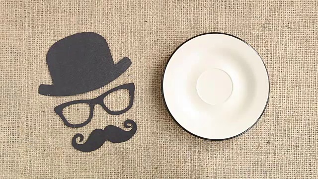 男性剪影图案与胡子，眼镜和帽子与咖啡杯在粗麻布的背景。十一月的概念。前列腺癌和男性健康意识视频下载