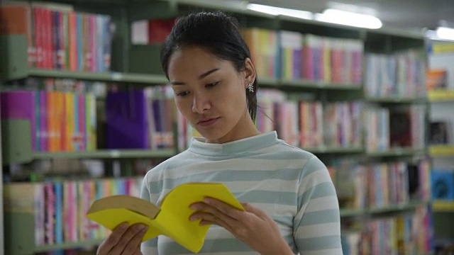 一位年轻女子在图书馆找书视频素材