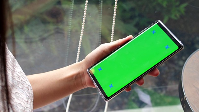 年轻女子使用绿色屏幕的智能手机视频素材