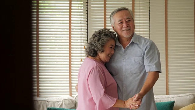 快乐的老年情侣在家里用慢镜头跳舞。视频素材