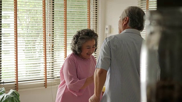 快乐的老年情侣在家里用慢镜头跳舞。视频素材