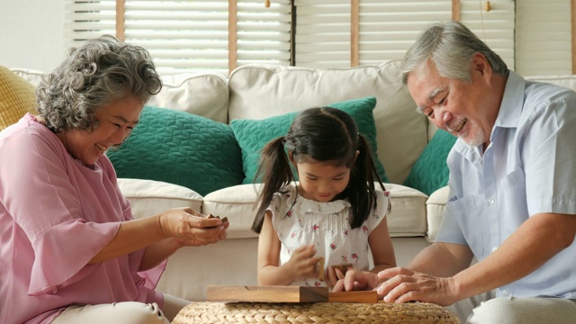 一对亚洲老夫妇在家里和一个小女孩一起玩。高级生活方式家庭理念。视频素材