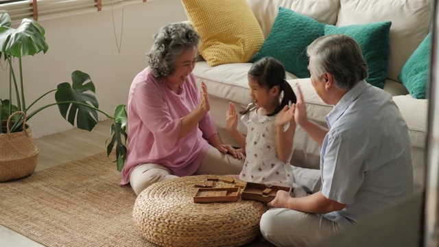 一对亚洲老夫妇在家里和一个小女孩一起玩。高级生活方式家庭理念。视频素材