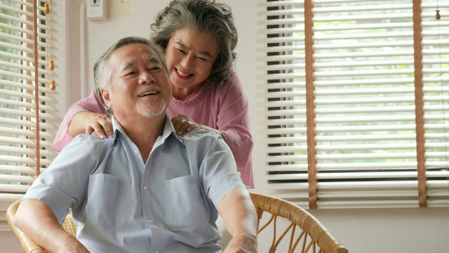 一位亚洲老人在家接受妻子的按摩。高级生活方式家庭理念。视频购买