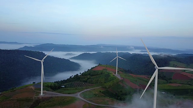 绿色能源风力涡轮机，鸟瞰日出从无人机飞行风力涡轮机视频素材