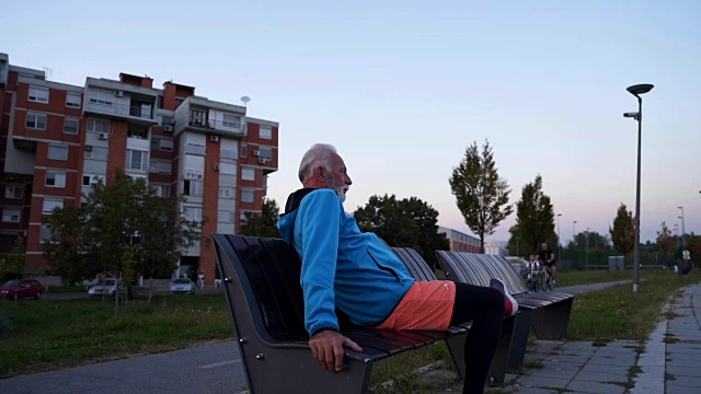 坚定的老人在慢跑后休息视频素材