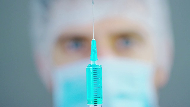 医生实验室里拿着注射器的医生或科学家为儿童或老年人注射液体疫苗，或治疗动物疾病视频素材