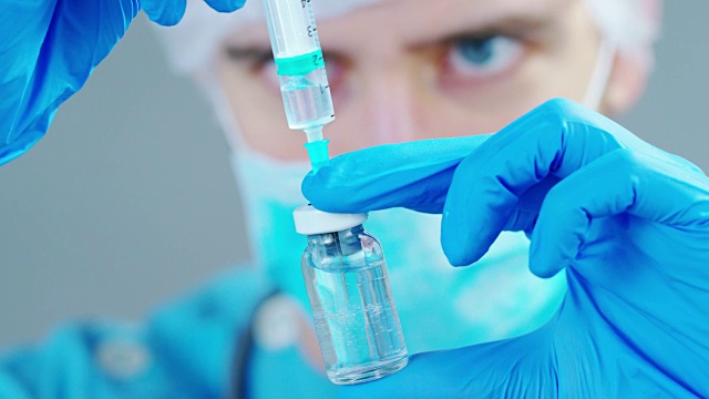医生实验室里拿着注射器的医生或科学家为儿童或老年人注射液体疫苗，或治疗动物疾病视频素材