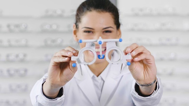 一位眼科医生在光学中心为客户做视觉检查的肖像。给病人试试眼镜。视频下载