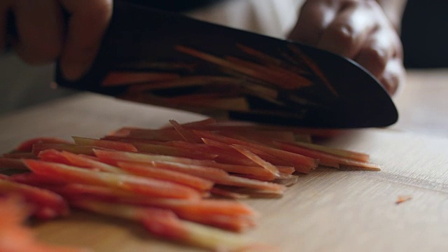 在切菜板上切胡萝卜。4k视频素材