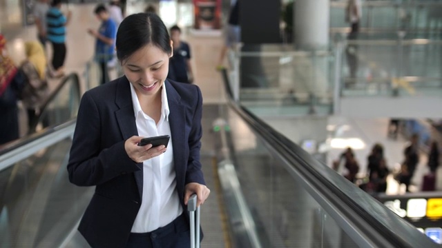 女商人在机场的自动扶梯上使用电话视频素材