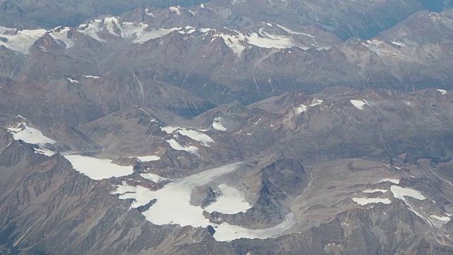 在夏季飞越欧洲阿尔卑斯山。冰川的景观。从飞机窗口鸟瞰图视频素材