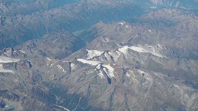 在夏季飞越欧洲阿尔卑斯山。冰川的景观。从飞机窗口鸟瞰图视频素材