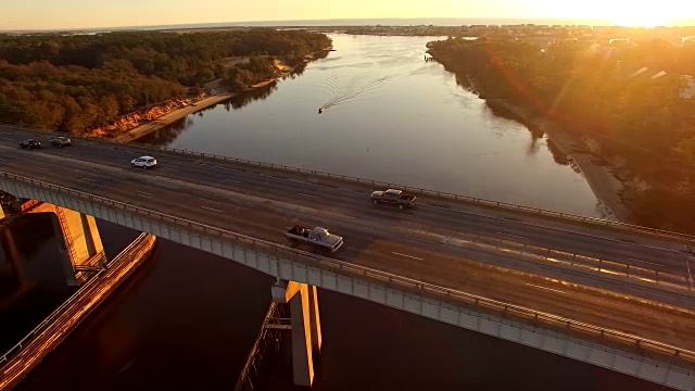 无人机鸟瞰图宁静的日出通过雪切桥和运河附近的卡罗来纳海滩视频下载