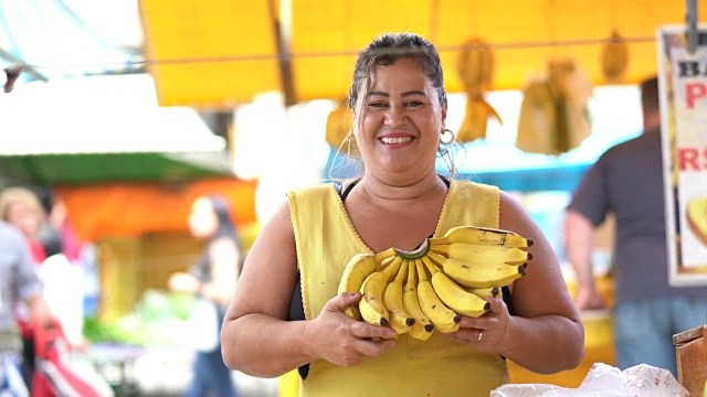 自信的主人肖像-在农贸市场卖香蕉视频素材