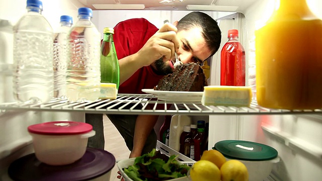 男人大吃特吃冰箱里的蛋糕视频素材
