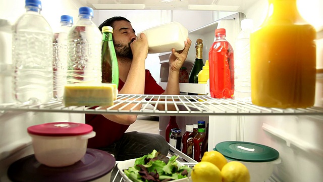 男人打开冰箱，从瓶子里喝牛奶视频下载
