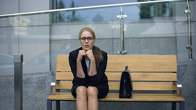 女职员坐在长凳上，担心工作上的麻烦，压力视频素材