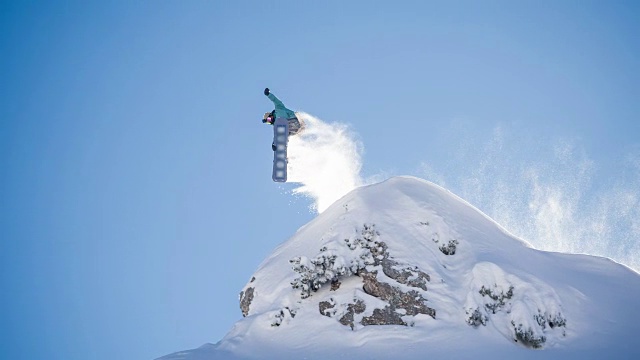 滑雪运动员从悬崖上跳下，落在刚下的雪上视频下载