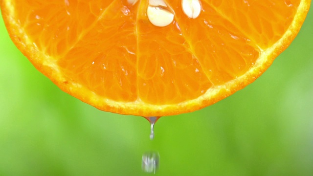水滴从橘子片上落下的慢动作。视频素材