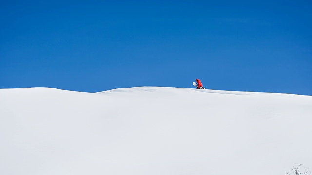 在一个晴朗阳光明媚的冬日里，滑雪板行走在雪地里视频素材
