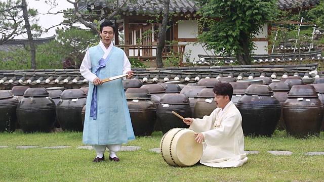 在户外与鼓手一起唱盘索里(一种由歌手和鼓手表演的韩国音乐叙事体裁)的歌手视频素材