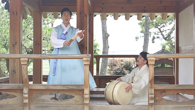 在凉亭里和鼓手一起唱盘索里(一种由歌手和鼓手表演的韩国音乐叙事体裁)的歌手视频素材